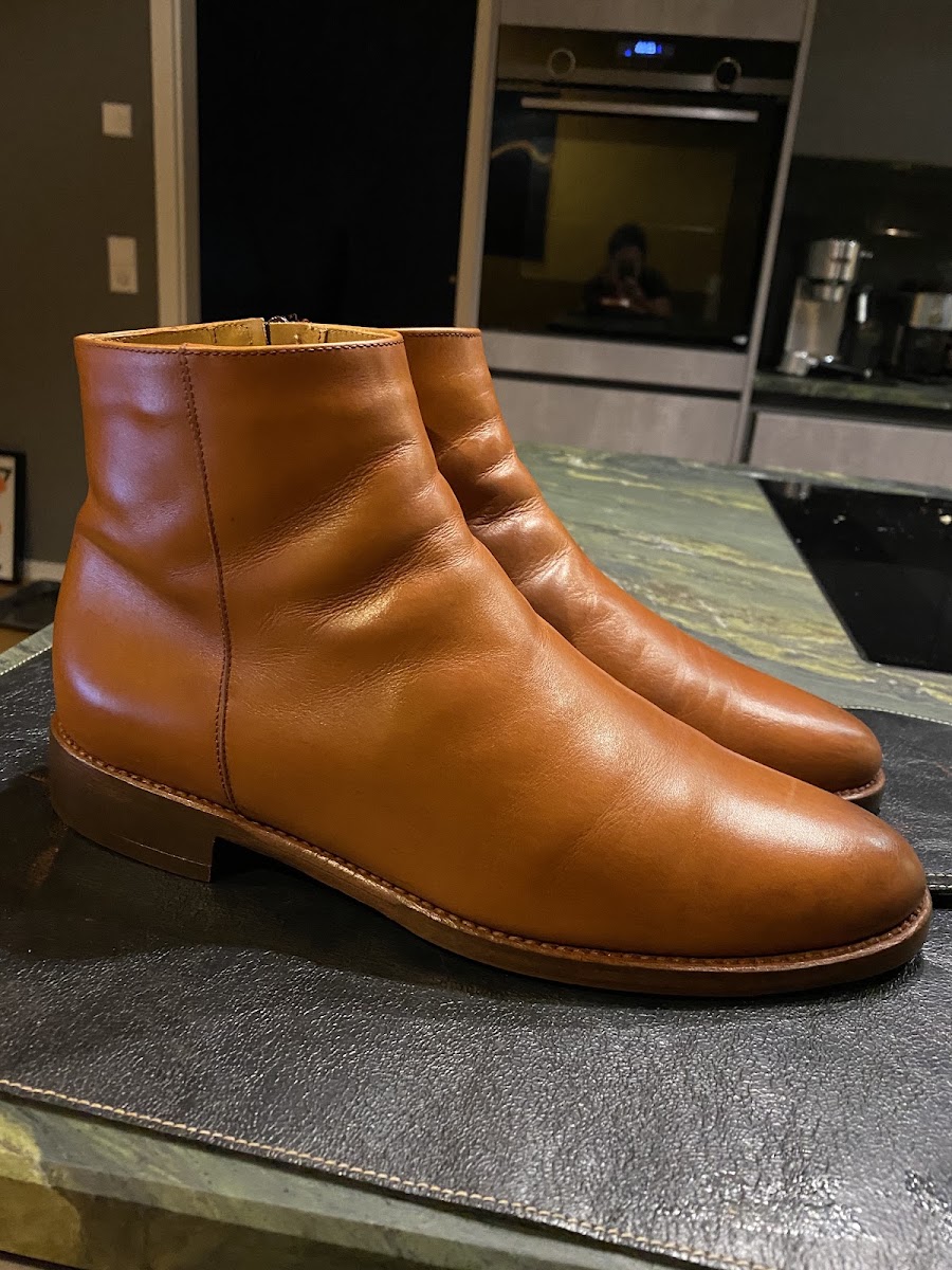 Paar cognacfarbene Lederstiefel nach der Reparatur